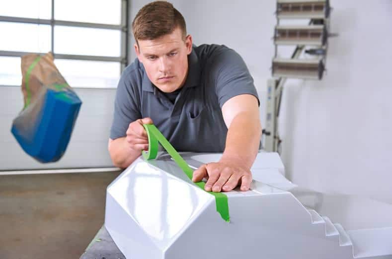 tesa blog image 2 a worker easily unwinding tesa 4338 high performance masking tape across the surface of what he is about to spray paint